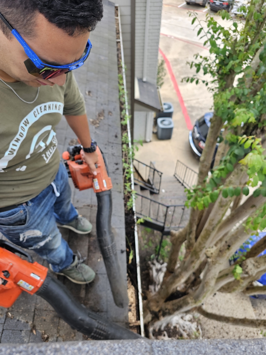TruShine technician clearing debris from a gutter with professional blowers